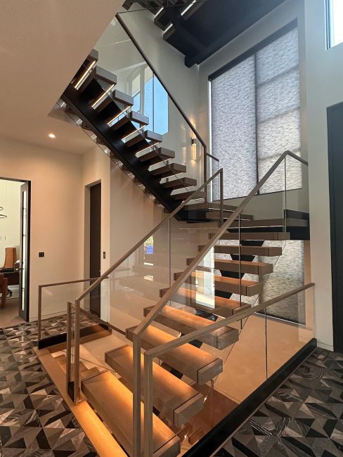 Architectural open riser staircase with glowing integrated light strips under wood steps
