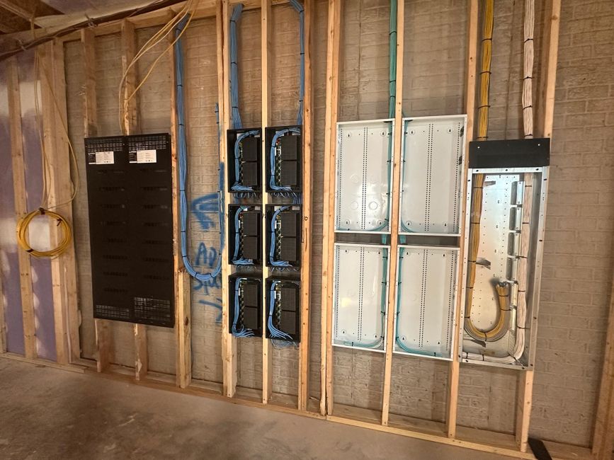 Row of empty white equipment enclosures and dark panels installed within wooden wall framing