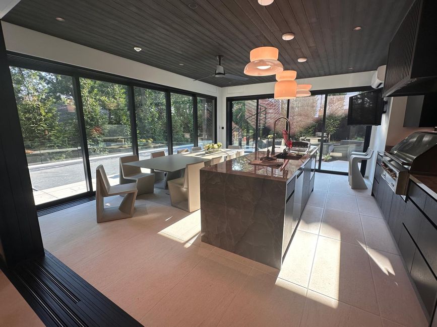 Indoor kitchen bar area featuring a dark marble island counter under orange tinted lights