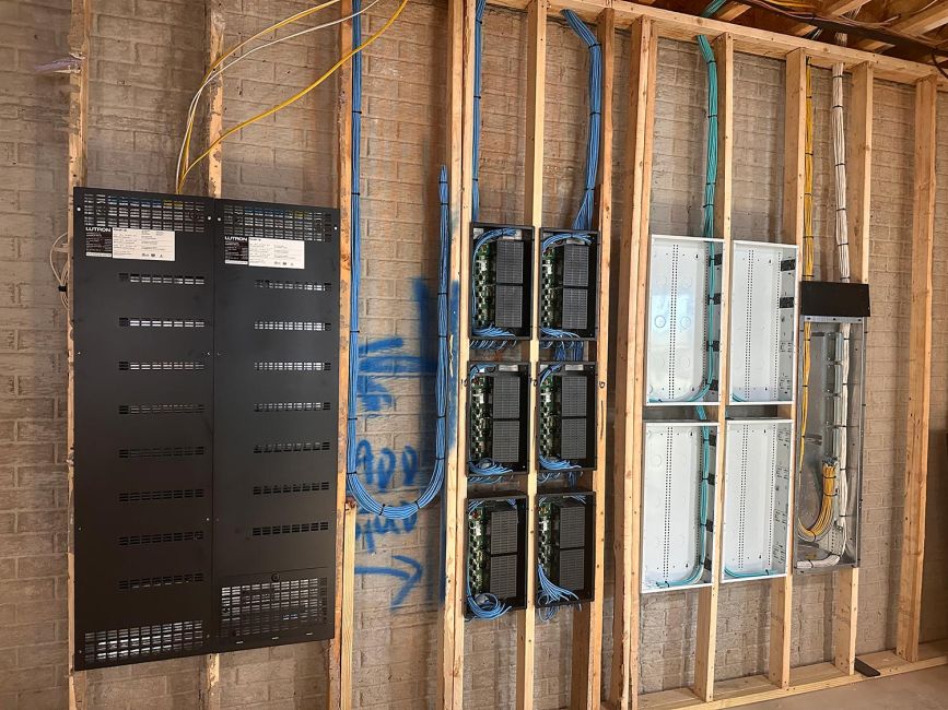 Low-voltage electronic modules and white metal enclosures mounted inside open wall studs