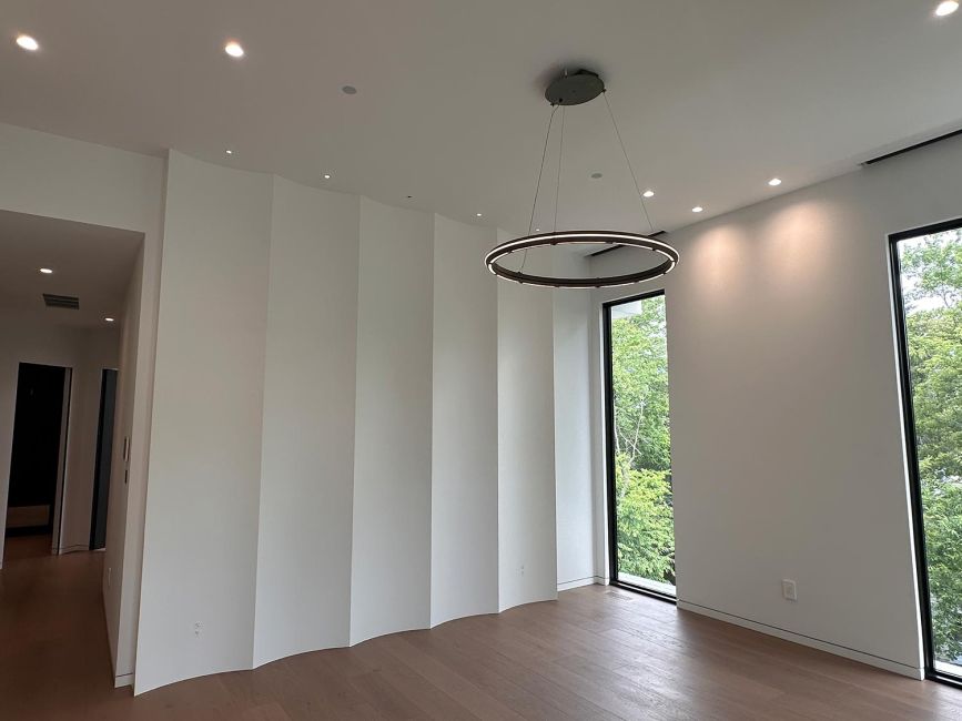 Minimalist room with white geometric accordion accent wall and circular ring light