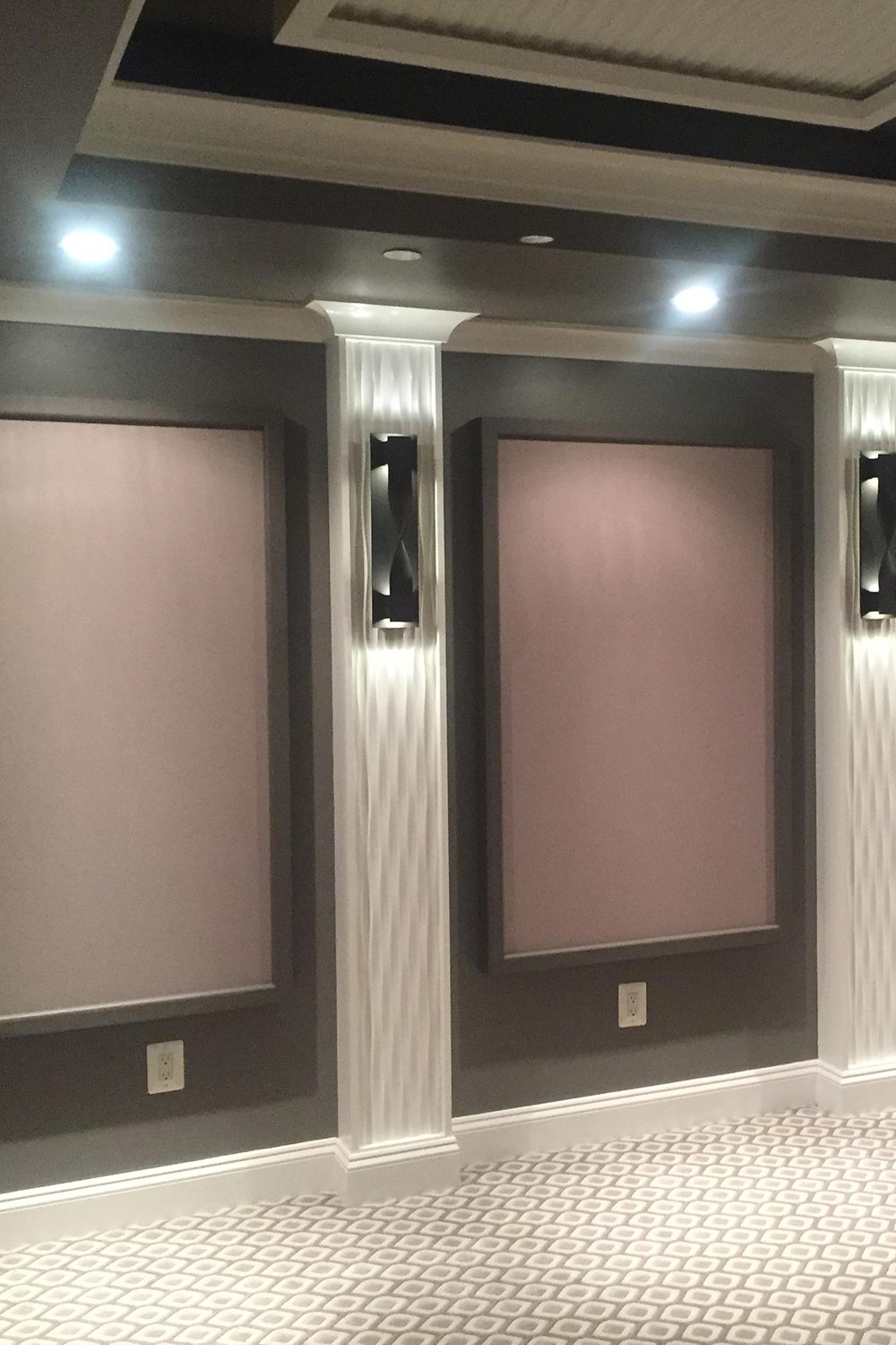 Pair of large rectangular fabric acoustic panels mounted on a gray wall with white pillars