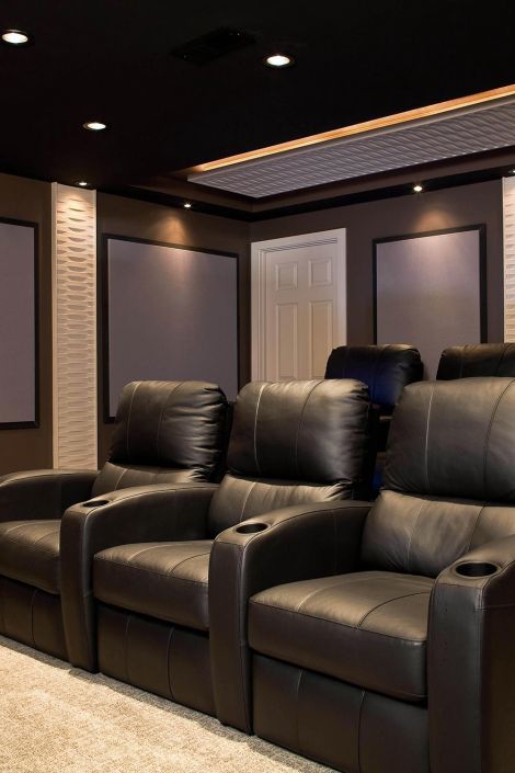 Row of black leather theater seats positioned in front of dark acoustic wall panels