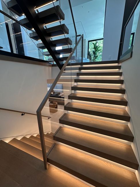 Modern structural open staircase with dramatic built-in step lighting elements