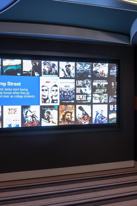 Close-up of a home theater projection screen displaying a movie selection menu