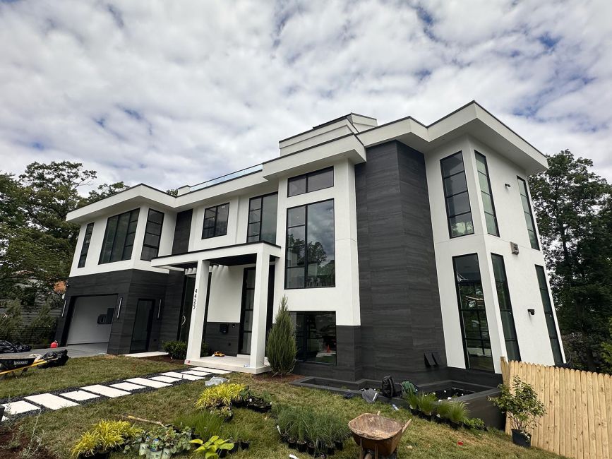 Modern two-story house with a white and dark grey facade and black framed windows