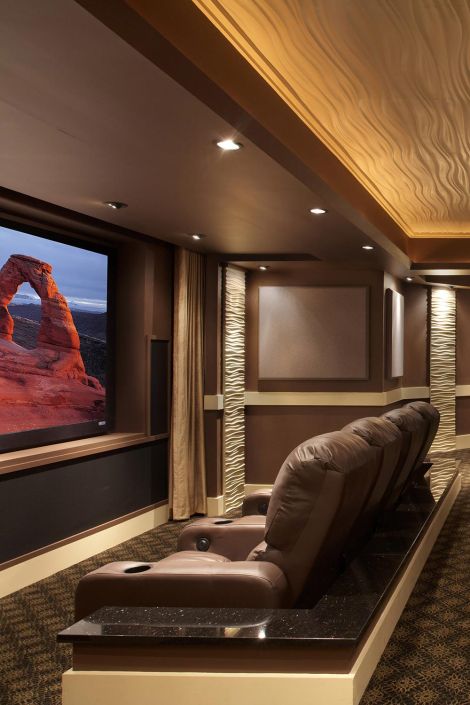 Home cinema featuring brown leather recliners, a large screen, and a textured wavy ceiling