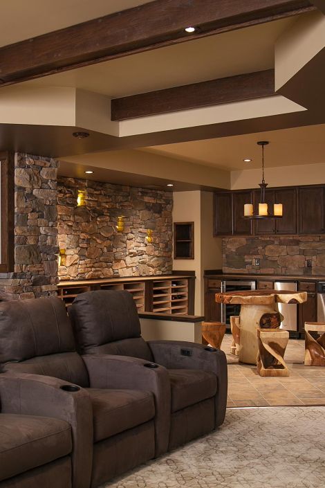 Home theater concession area featuring a stone wall, wooden table, and wine storage