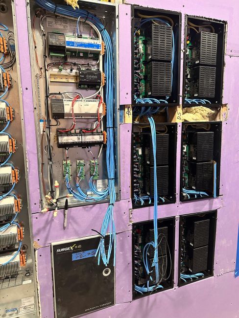 Structured low-voltage wiring panel with blue cables and multiple electronic modules