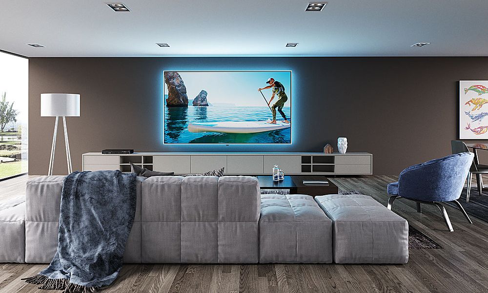 Living room with big wall mounted TV with backdrop lights